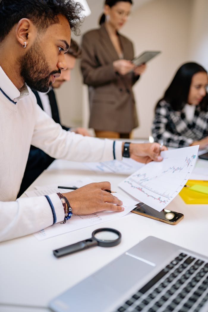 Focused professionals analyzing documents in a collaborative business meeting setting.